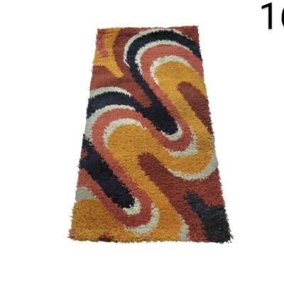 Alfombra de la colección Momeni Novogratz Retro con un diseño de ondas multicolores en tonos naranja, amarillo, negro y crema alquiler para eventos, publicidad, peliculas y series