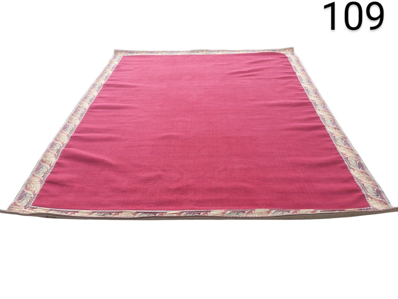Alfombra de área tradicional con un borde estampado y un centro rojo vibrante alquiler para eventos, publicidad, pelicula y series