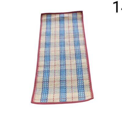 Alfombra de paja natural con un patrón de cuadros azules y rojos, bordeadas con una cinta roja alquiler para eventos, publicidad, peliculas y series