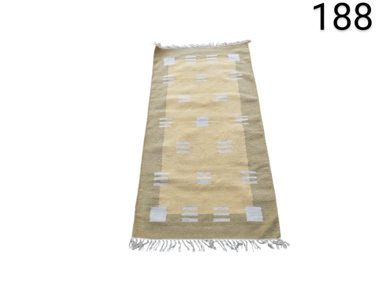 Kilim style wool hallway rug, handmade in India with a geometric pattern in beige and earth tones, for rent for events, advertising, films and series.