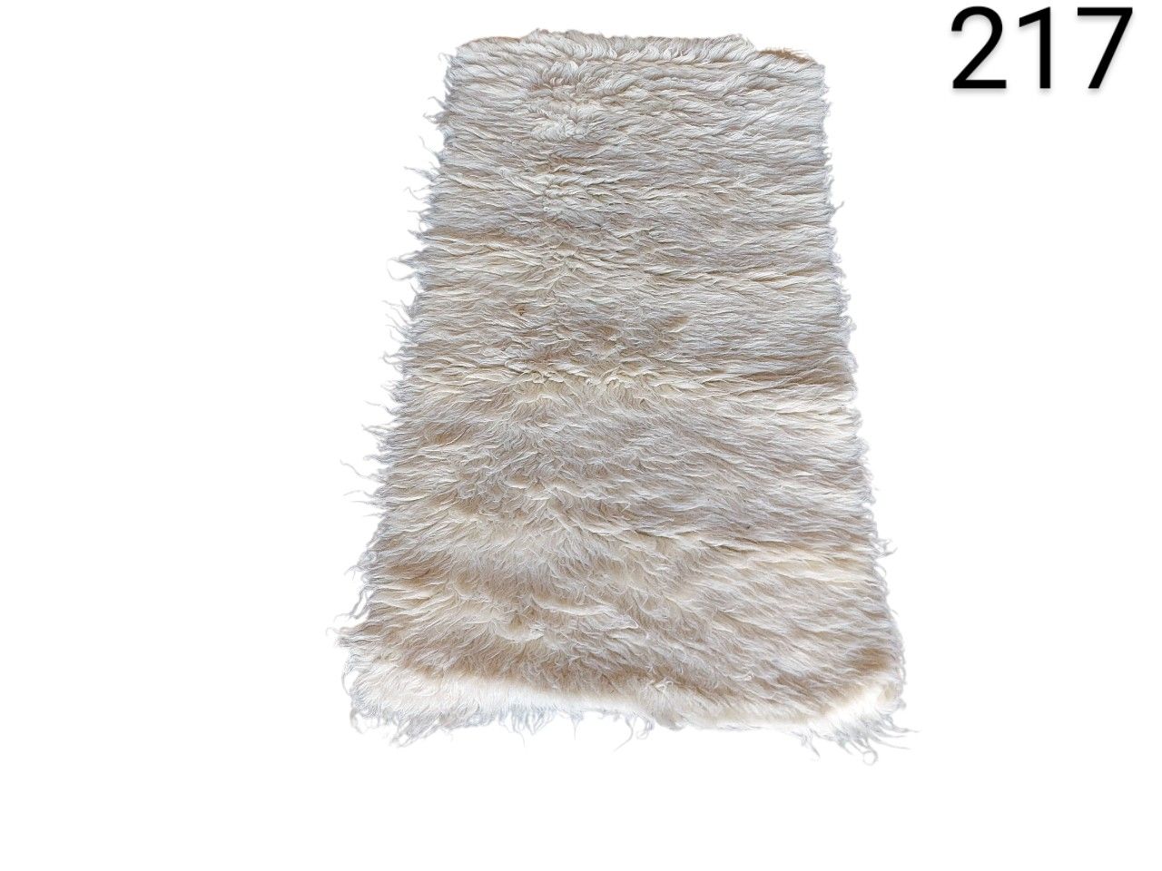 Tibetan sheepskin rug in beige or cream with long curly pile for rent for events, advertising, films and series.