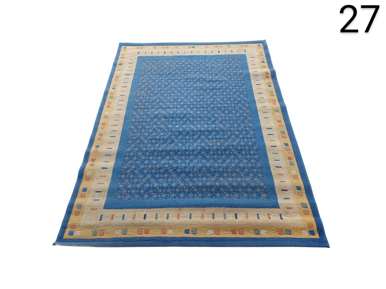 Alfombra de salón de diseño geométrico en tonos azules y beige alquiler para eventos, publicidad, peliculas y series