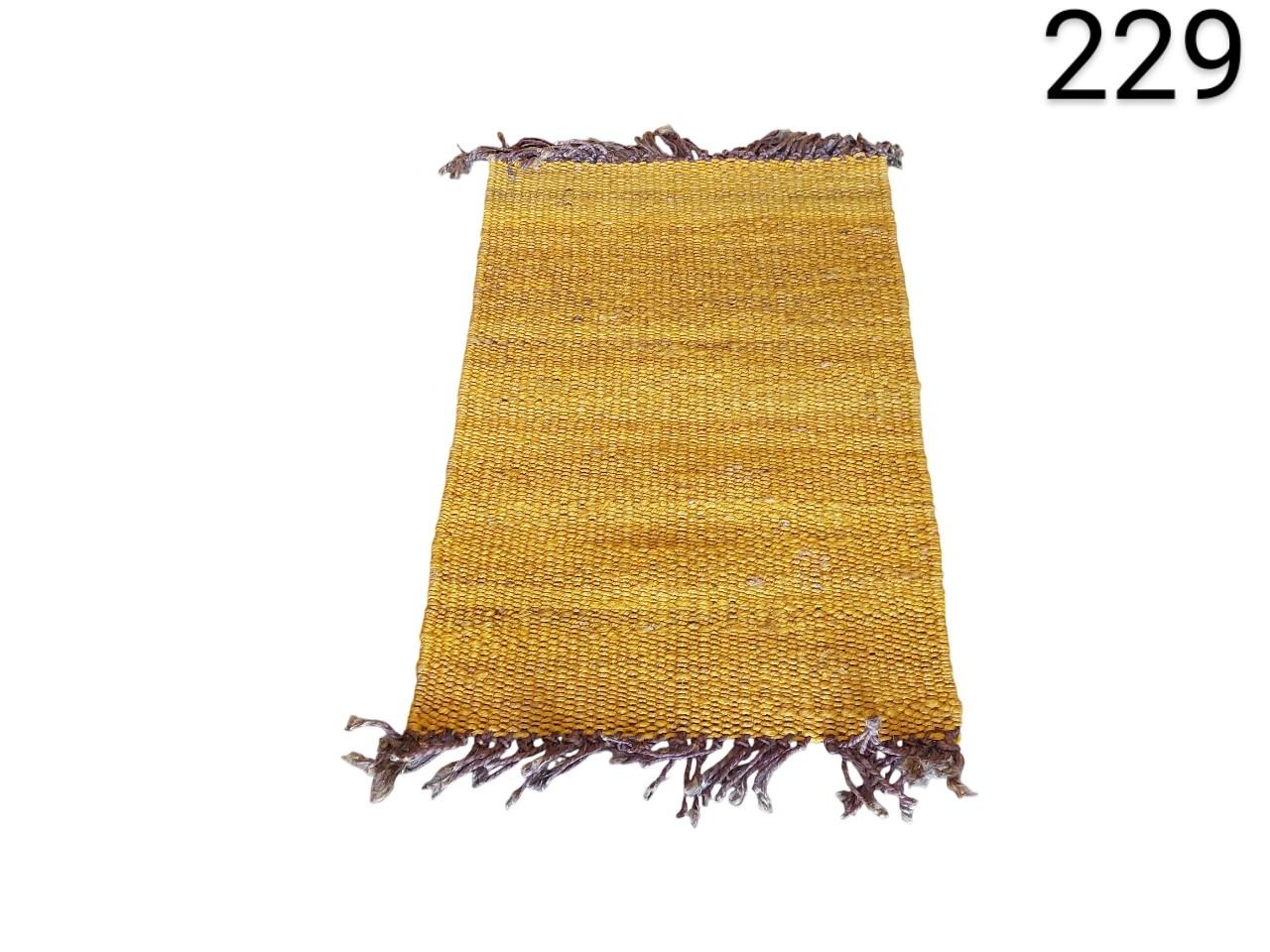 Alfombra de tejido plano estilo kilim en color amarillo mostaza con flecos marrones alquiler para eventos, publicidad, peliculas y series
