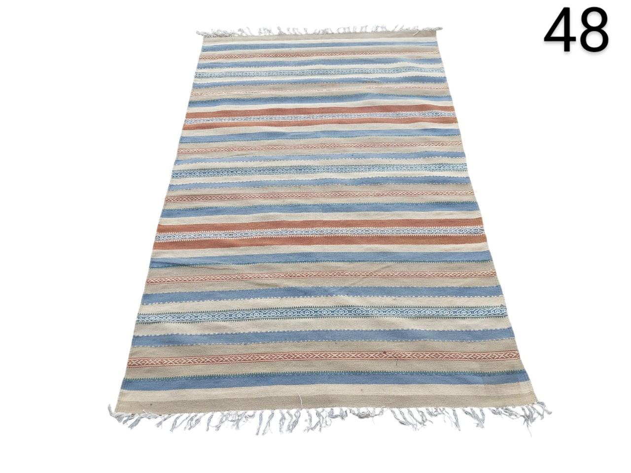 Alfombra de tejido plano estilo kilim multicolor con rayas horizontales en tonos azules, beige y terracota alquiler para eventos, publicidad, peliculas y series