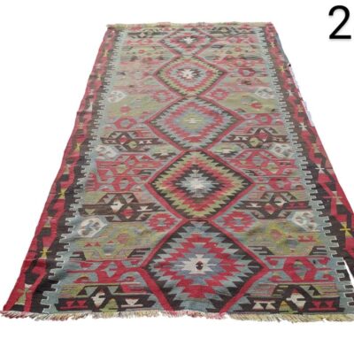 Alfombra es una alfombra turca vintage tipo Kilim con un diseño geométrico de rombos en tonos rojos y verdes alquiler para eventos, publicidad, peliculas y series