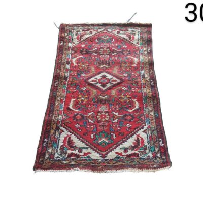 Alfombra oriental antigua hecha a mano, con un diseño geométrico de medallón central en tonos rojos alquiler para eventos, publicidad, peliculas y series