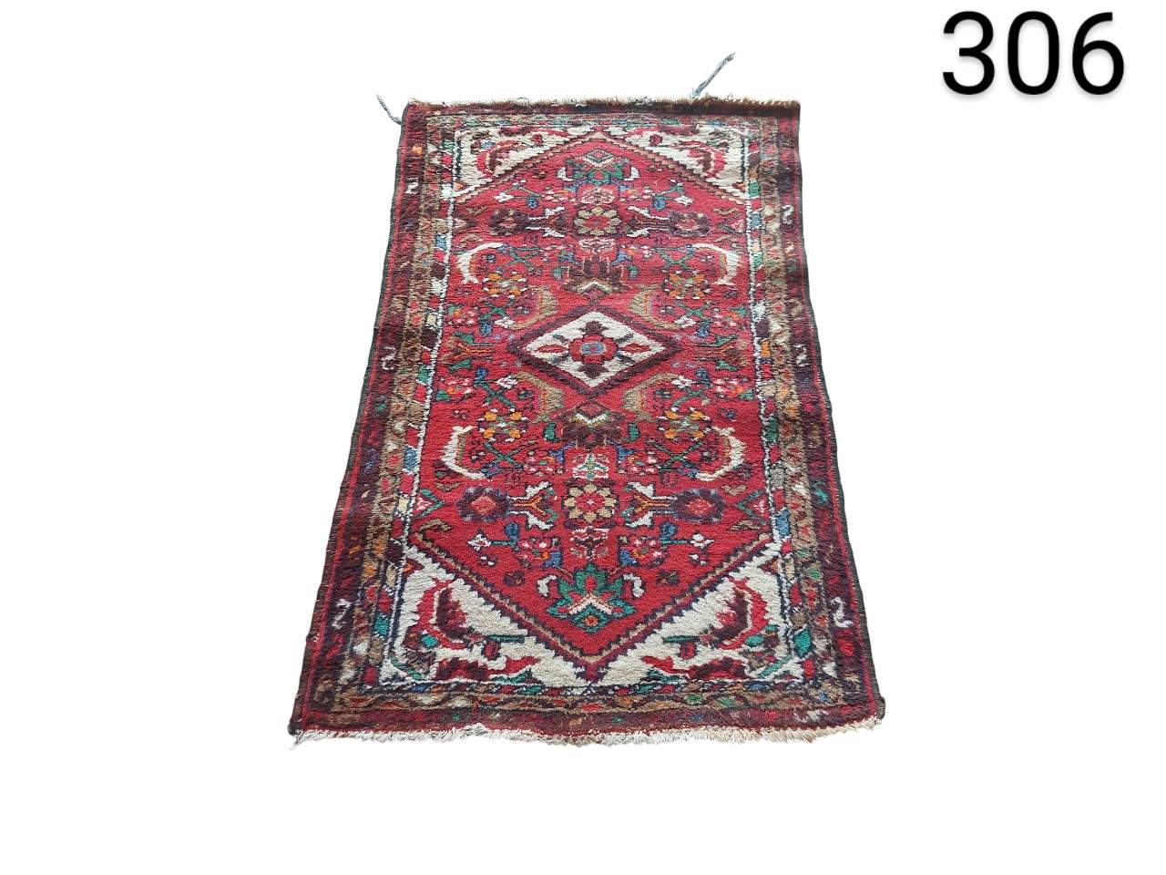 Alfombra oriental antigua hecha a mano, con un diseño geométrico de medallón central en tonos rojos alquiler para eventos, publicidad, peliculas y series