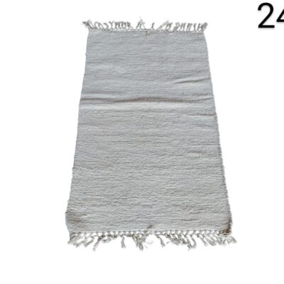 Alfombra tejida de color beige claro con flecos blancos en los extremos alquiler para eventos, publicidad, peliculas y series