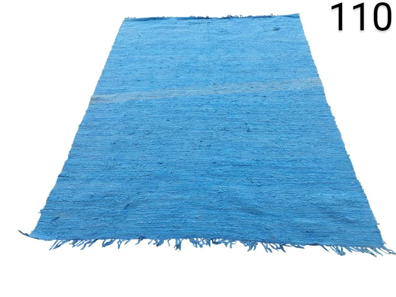 Flat weave dhurrie type carpet made of 100% cotton, often marketed by brands such as Theko in a turquoise or bright blue colour for rental for events, advertising, films and series.