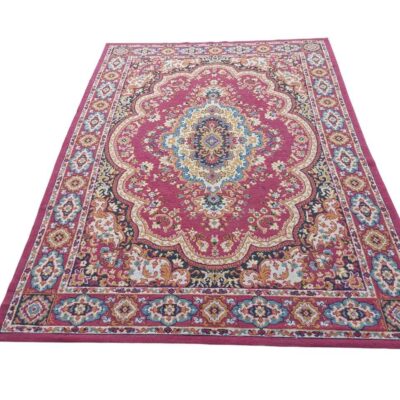 Alfombra tradicional de estilo persa con un diseño floral y medallón central en tonos fucsia, rojo, beige y azul alquiler para eventos, publicidad, peliculas y series