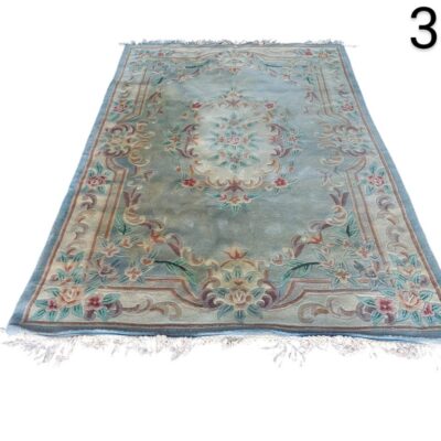 Alfombra tradicional de lana estilo Aubusson francesa con motivos florales en tonos rosa, beige y verde sobre un fondo azul alquiler para eventos, publicidad, peliculas y series