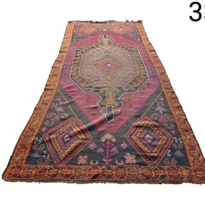Alfombra turca vintage de lana con un patrón geométrico en tonos rosa y ciruela alquiler para eventos, publicidad, peliculas y series