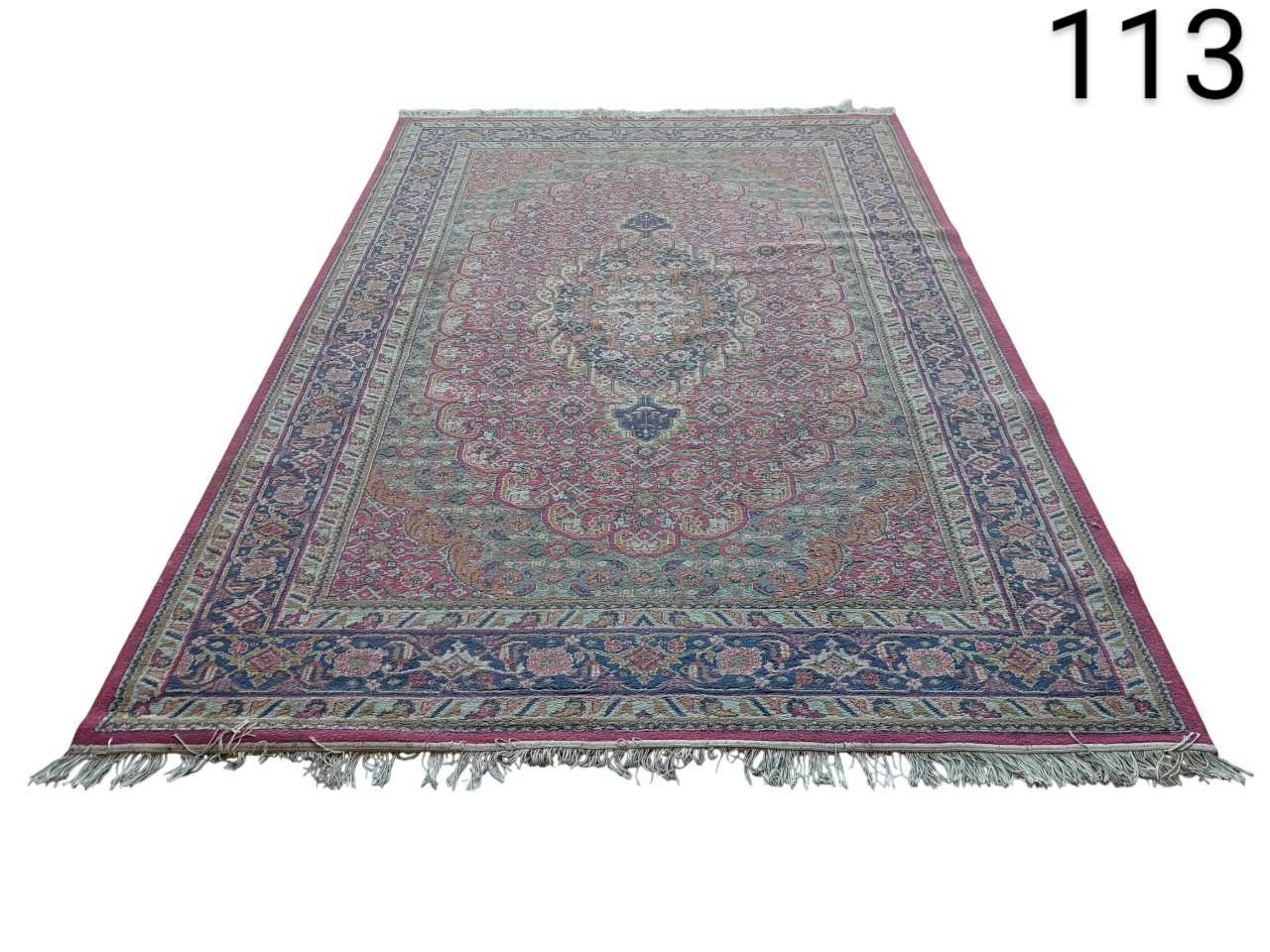 Carpet is a vintage hand-knotted wool piece, possibly Turkish or Persian style, with traditional floral patterns in shades of pink and blue. rental for events, advertising, films and series