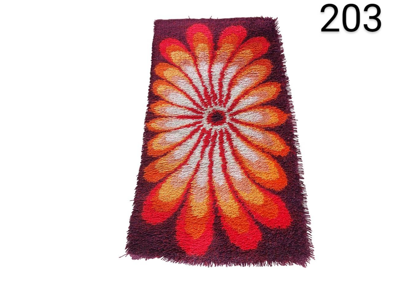 Vintage 1970's carpet features a vibrant floral design in shades of orange, red and brown for rent for events, advertising, films and series.