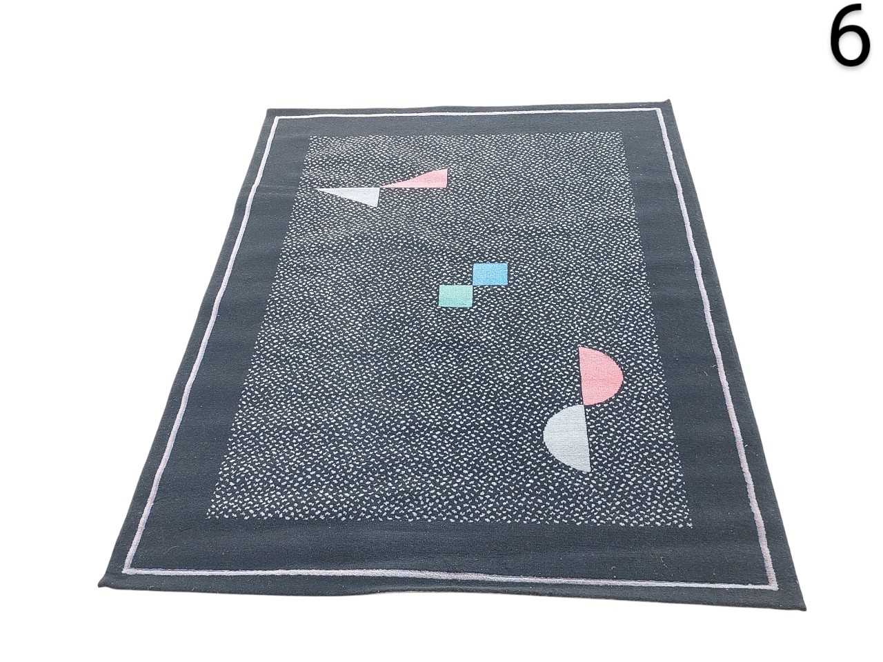contemporary geometric rug with an abstract pattern of shapes in pastel shades on a dark background