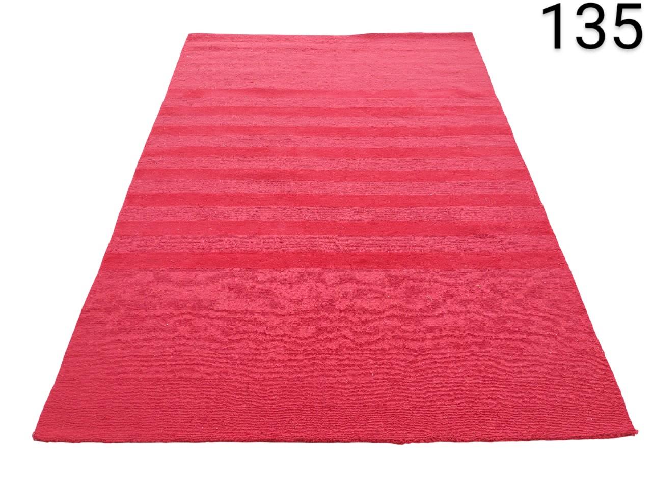 Alfombra roja de diseño rayado, probablemente un modelo tipo Kilim o dhurrie hecho de lana o algodón alquiler para eventos, publicidad, peliculas y series
