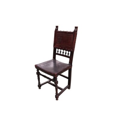 This antique Henry II Renaissance-style chair is made from carved wood with an embossed leather seat and backrest; available for hire for events, advertising, films and TV series
