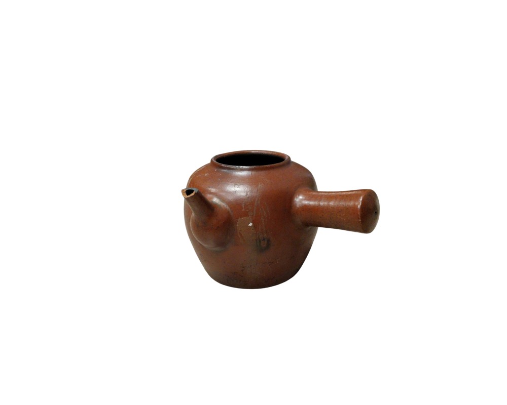 ceramic teapot with a natural finish in earthy and reddish tones, characterised by a globular body with a wide top opening, a short spout and a distinctive cylindrical handle positioned at an angle on the side; available for hire for events, advertising, films and TV series