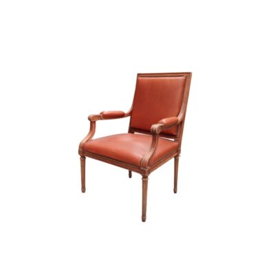 Sillón de estilo Luis XVI presenta una estructura de madera tallada y tapicería de piel habana con remaches alquilr para eventos, publicidad, peliculas y series