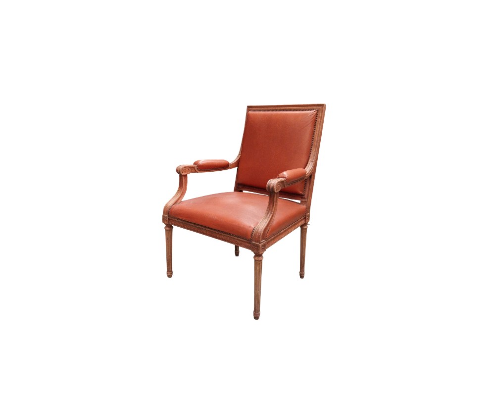 Sillón de estilo Luis XVI presenta una estructura de madera tallada y tapicería de piel habana con remaches alquilr para eventos, publicidad, peliculas y series