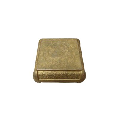 A metal box with an antique gold finish, characterised by a rectangular shape with rounded edges and a top and bottom surface entirely decorated with fine traditional engravings featuring ornamental motifs and circular figures in relief; available for hire for events, advertising, films and TV series