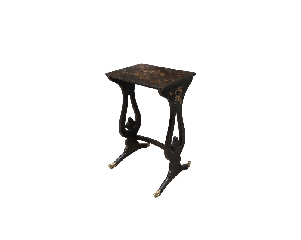 mesa auxiliar pequeña de tonos oscuros, caracterizada por un tablero superior rectangular decorado con finos motivos dorados, soportes laterales curvados de diseño estilizado y patas con terminales metálicos alquiler para eventos, publicidad, peliculas y series