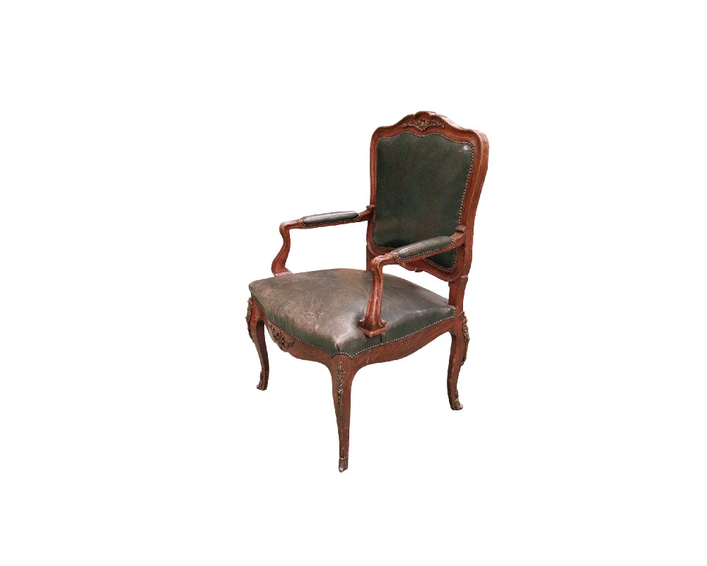 This Louis XV armchair is made from carved walnut and upholstered in green leather; available for hire for events, advertising, films and TV series