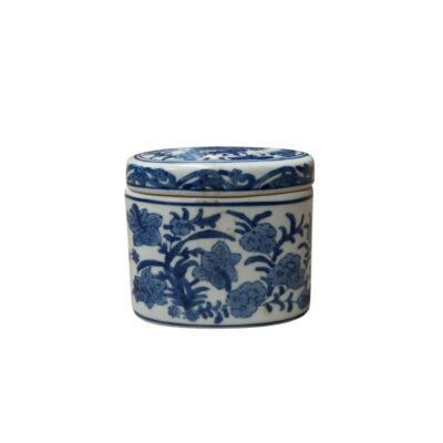 A small cylindrical porcelain box, consisting of a base and a snap-on lid. It features delicate cobalt blue decoration on a white background, using a traditional technique from Oriental ceramics, depicting motifs of flowers and foliage intertwined around the body. Available for hire for events, advertising, films and TV series.