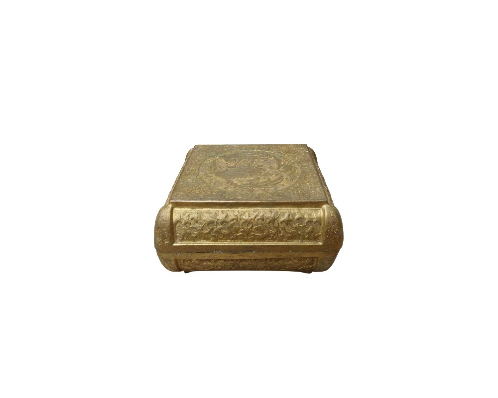 caja de metal con un acabado dorado envejecido, caracterizada por una forma rectangular de bordes redondeados y una superficie superior e inferior completamente decorada con finos grabados tradicionales que presentan motivos ornamentales y figuras circulares en relieve alquiler para eventos, publicidad, peliculas y series