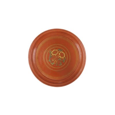 comprising four ceramic pieces in circular and octagonal shapes, finished in shades of terracotta and ochre, characterised by raised rims and an interior surface decorated with floral and geometric motifs painted in fine detail; available for hire for events, advertising, films and TV series