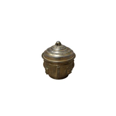 A metal vessel with a cylindrical body decorated with relief carvings of faces across its surface, and a domed lid finely detailed with borders and a knob on top; available for hire for events, advertising, films and TV series
