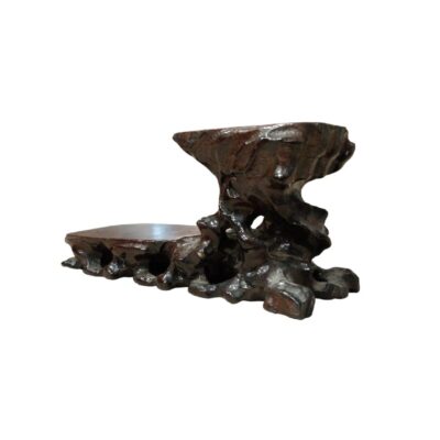 base de exhibición o peana de madera tallada con un diseño asimétrico de doble nivel. Su estructura combina una plataforma baja con una sección elevada y esculpida de forma orgánica, que imita texturas naturales alquiler para eventos, publicidad, peliculas y series
