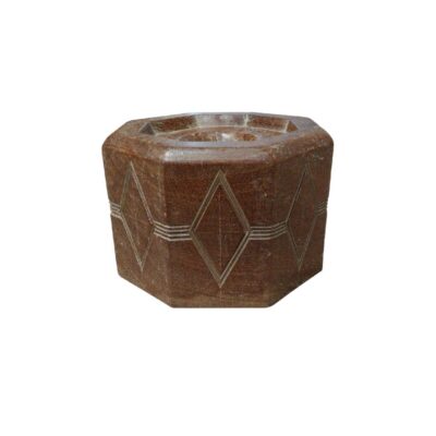 Su distintiva forma octogonal, combinada con un delicado patrón geométrico de rombos grabado en los laterales, lo convierte en una pieza decorativa de gran personalidad. Gracias a la singularidad de la piedra, cada unidad presenta vetas y tonos únicos, ofreciendo un acabado orgánico y atemporal. Es el complemento ideal para crear ambientes íntimos y sofisticados, integrándose perfectamente tanto en decoraciones minimalistas como en estilos más rústicos o étnicos