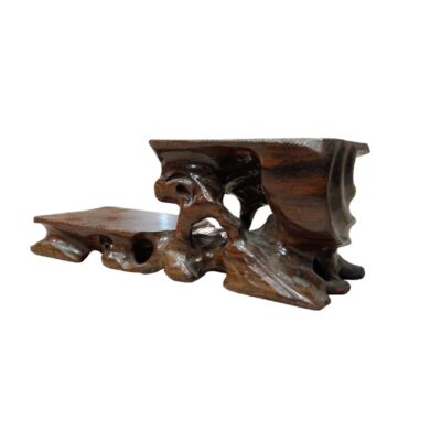 peana de madera tallada con un diseño asimétrico de doble nivel. Su estructura combina una plataforma baja con una sección elevada y esculpida de forma orgánica, que imita texturas naturales alquiler para eventos, publicidad, peliculas y series