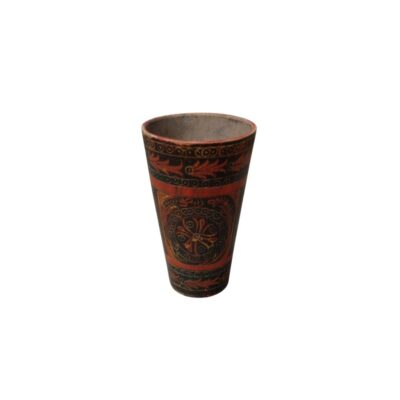 vaso de madera de forma cónica y alargada, caracterizado por un acabado exterior detalladamente pintado a mano en tonos oscuros y rojizos con complejos patrones geométricos, florales y rosetones circulares alquiler para eventos, publicidad, peliculas y series