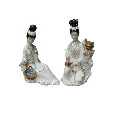 A pair of porcelain figurines depicting two ladies dressed in traditional oriental costumes, characterised by their fine finish and delicately painted details; available for hire for events, advertising, films and TV series