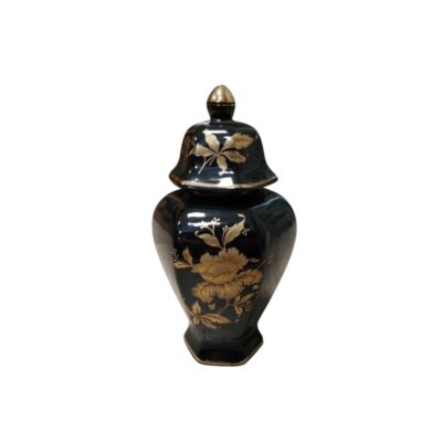 Porcelain with a glossy black finish and a polygonal body, characterised by an elegant floral decoration in golden tones that stands out against its surface, and a matching lid with a rounded top. Available for hire for events, advertising, films and TV series.