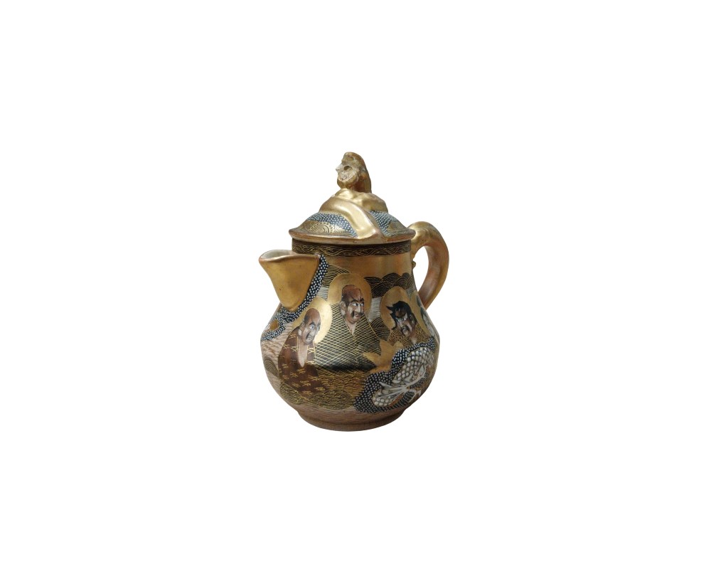 tetera ornamental que destaca por su rica decoración y estilo tradicional. El cuerpo de la tetera está decorado con representaciones de figuras, posiblemente monjes o personajes mitológicos, integradas en un diseño con patrones geométricos y fondos oscuros acentuados por detalles en color dorado alquiler para eventos, publicidiad, peliculas y series