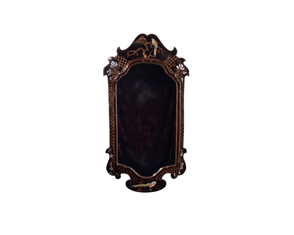 Vertical wall mirror with a dark frame featuring sinuous, cut-out shapes, characterised by delicate mother-of-pearl inlays and gilded details depicting motifs of birds, branches and flowers; available for hire for events, advertising, films and TV series