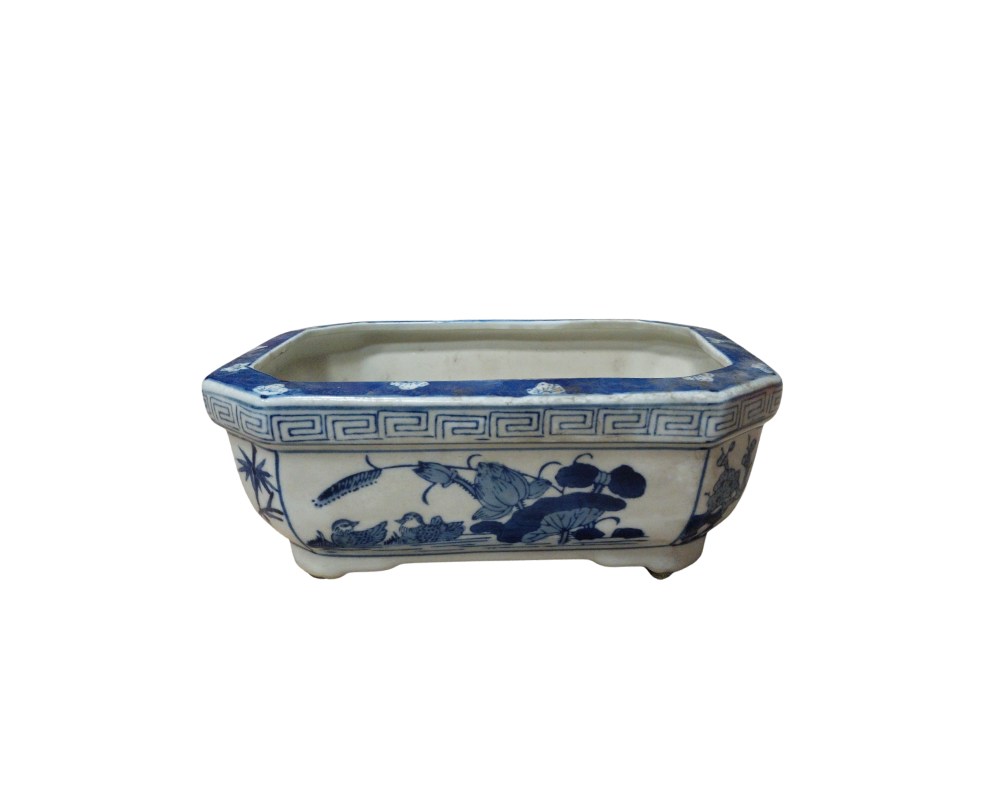 A rectangular flowerpot with octagonal edges, made of porcelain. It is decorated using the traditional cobalt blue technique on a white background, featuring aquatic scenes; available for hire for events, advertising, films and TV series