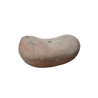 soporte de cerámica con una forma curva y alargada, similar a una almohada o cabezal tradicional, con tonos terrosos y un pequeño orificio perforado en su parte central superior alquiler para eventos, publicidad, peliculas y series