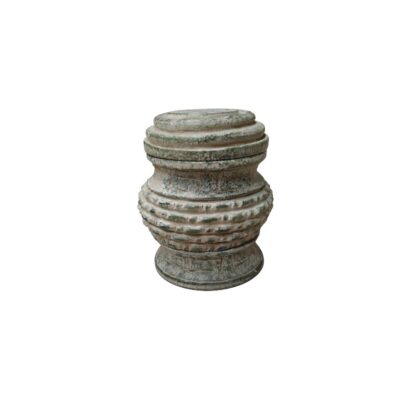 A compact, cylindrical object crafted from stone with a textured finish and weathered tones. It features a segmented structure comprising a snug-fitting lid and geometric decorations carved into its central body. This handcrafted piece, with its austere and traditional aesthetic, serves as an elegant decorative centrepiece or as a specialised container for calligraphy, evoking an antique style. Available for hire for events, advertising, films and TV series.