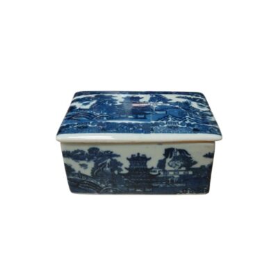 A rectangular porcelain box with a lid, decorated using the traditional cobalt blue technique on a white background. The design features a detailed landscape scene reminiscent of the famous ‘Willow’ pattern, available for hire for events, advertising, films and TV series