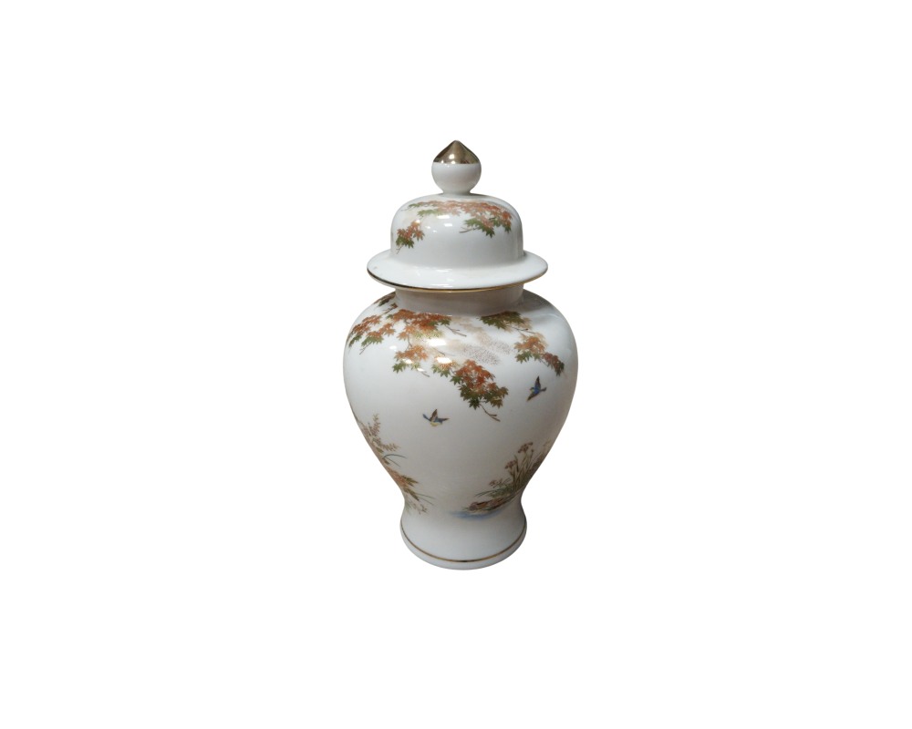 A white porcelain vase with a glossy finish, characterised by a globular shape, a stable base, a short neck and a matching lid with a gold-coloured trim. Its surface is delicately decorated with traditional motifs depicting trees, landscapes and birds in flight, with details in gold and polychrome tones. Available for hire for events, advertising, films and TV series.