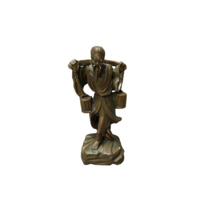 A metal sculpture with a bronze finish, depicting an elderly man with a beard, dressed in traditional clothing, carrying a pole on his shoulders from which two buckets hang. The figure stands on a base that resembles a rocky surface; available for hire for events, advertising, films and TV series