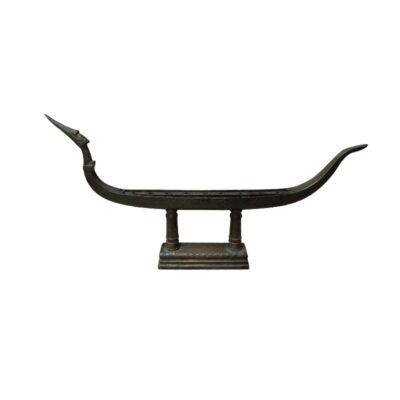 scultura de metal de aspecto envejecido que representa una embarcación tradicional estilizada, caracterizada por una proa elevada con cabeza de animal o ave, popa curva y un cuerpo alargado sostenido sobre columnas dobles y una base rectangular decorada alquiler para eventos, publicidad, peliculas y series