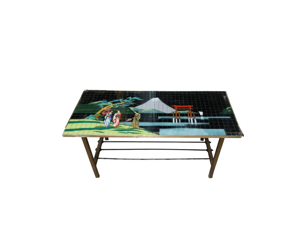 A rectangular coffee table characterised by a top surface composed of small tiles or tesserae forming a traditional Japanese landscape mosaic, including figures in kimonos, a snow-capped mountain and a torii gate, supported by a metal frame with reinforcing cross-bars at the base. Available for hire for events, advertising, films and TV series