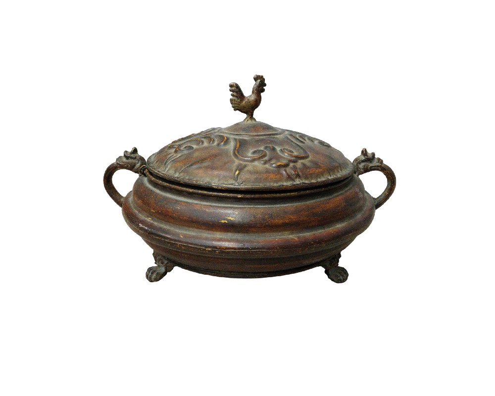 Esta elegante pieza de artesanía destaca por su cuidada ornamentación metálica y su diseño clásico. El recipiente, que incluye una tapa con un distintivo remate en forma de ave y asas laterales trabajadas, es una muestra de equilibrio y detalle decorativo. Ideal para realzar la estética de mesas o aparadores, este contenedor aporta un toque de distinción histórica y sofisticación a cualquier ambiente, siendo perfecto tanto para coleccionistas como para quienes valoran las piezas con carácter tradicional.