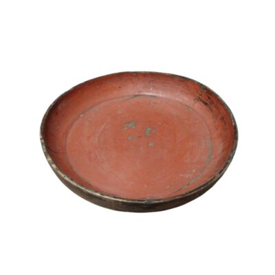 A circular wooden tray, characterised by a low-rimmed design and an interior surface with a traditional reddish finish, showing signs of use and wear consistent with its age. Available for hire for events, advertising, films and TV series.