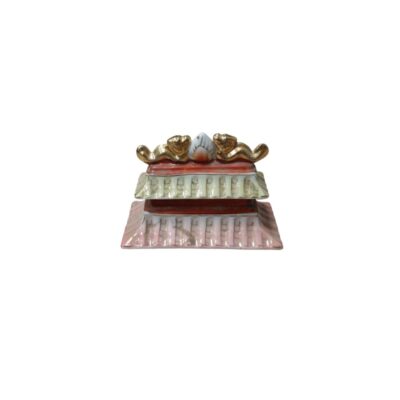 tapa de cerámica de diseño tradicional y multinivel, caracterizada por secciones que imitan tejas superpuestas en tonos rosados y claros, bordes rojizos y un remate superior dorado con figuras esculpidas alquiler para eventos, publicidad, peliculas y series
